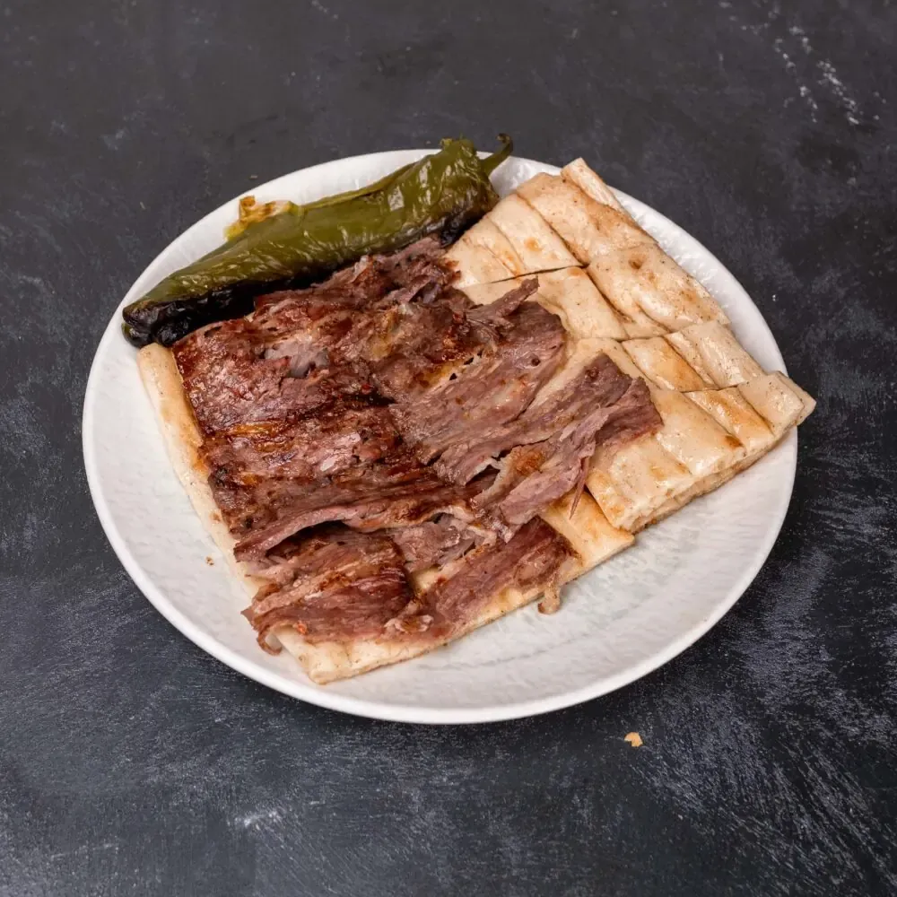 Lila Gusto yaprak döner porsiyonu; pide ve közlenmiş biberle sunumu