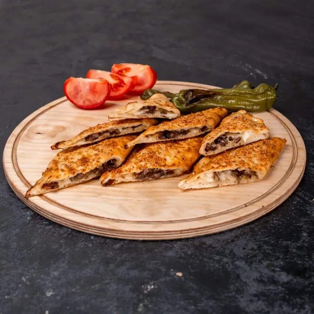 Lila Gusto QR menüsünden dönerli pide; ahşap sunum üzerinde dilimlenmiş pide görseli