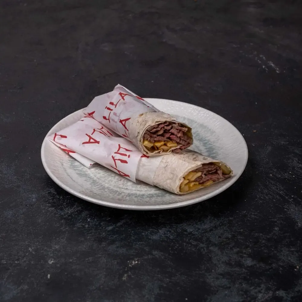Lila Gusto Dürüm Döner; markalı kâğıtta, ikiye kesilmiş dürüm