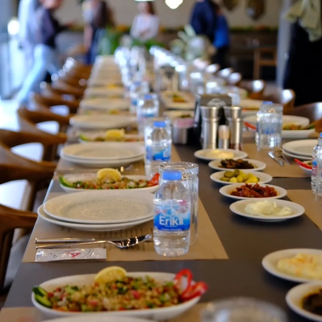 Lila Gusto’da yemeklerin ve içeceklerin bulunduğu uzun bir buluşma sofrası